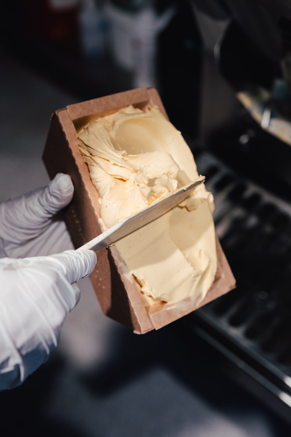 Frisches Eis wird mit dem Spachtel in eine Kartonbox zum Abholen gefüllt